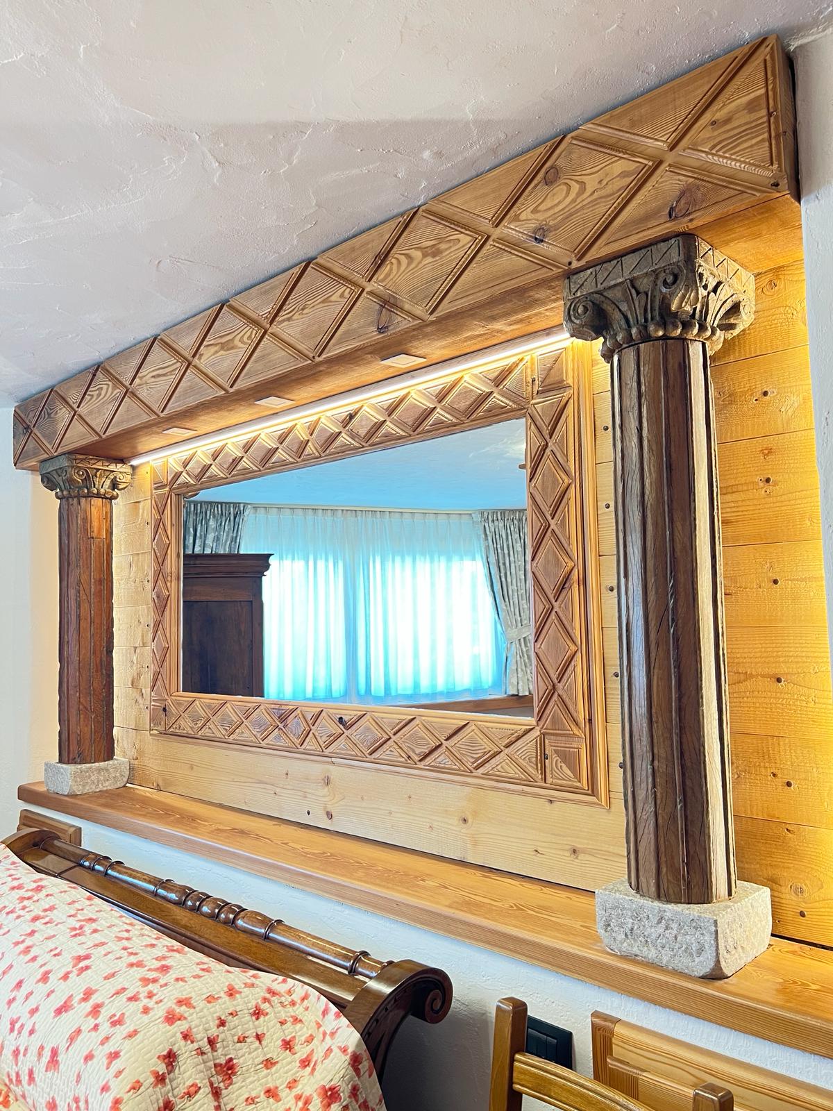 Specchio con cornice lavorata e colonne in legno